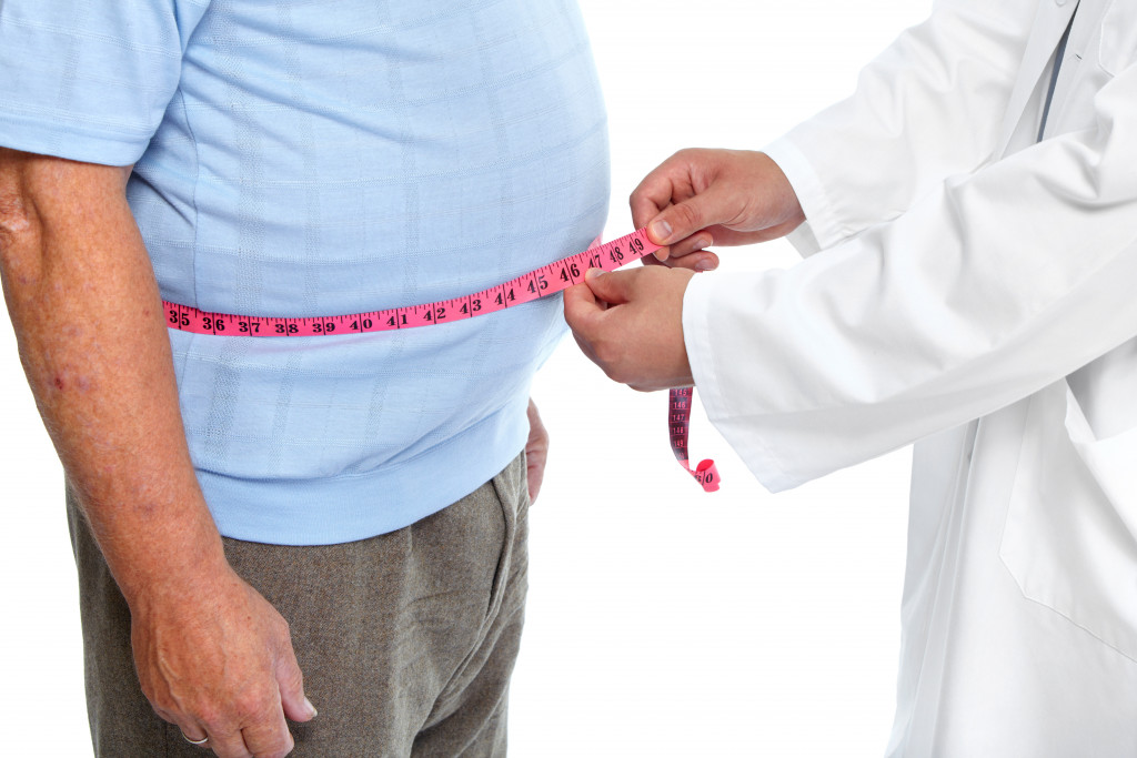 Obese old man being measured