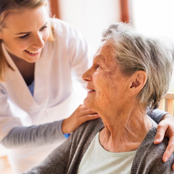 caregiver smiling at an elder woman