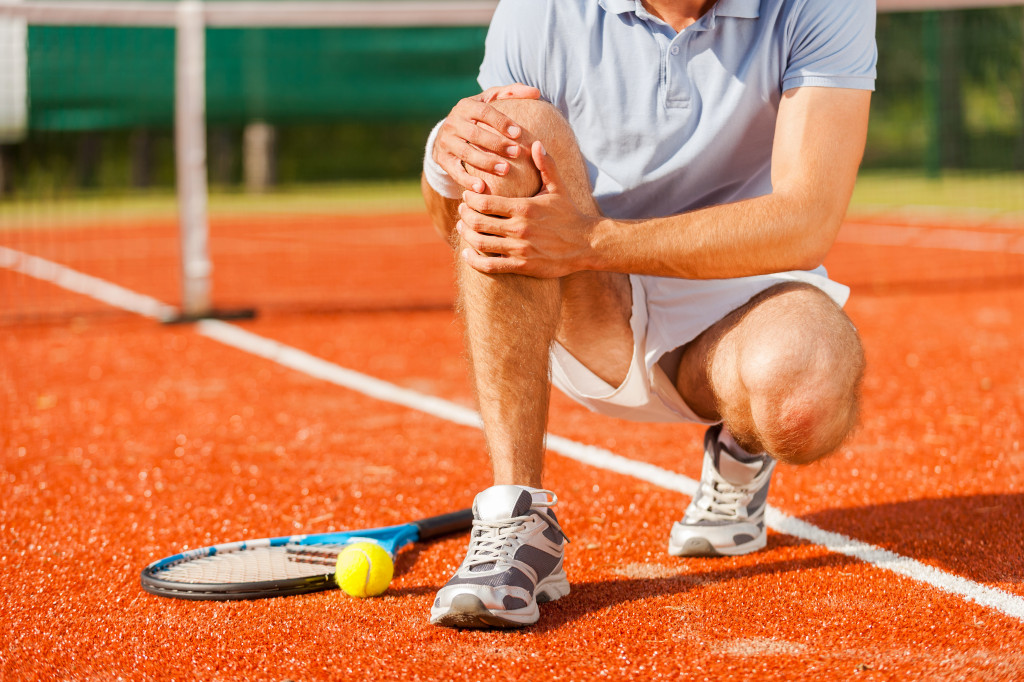 tennis player holding his knees